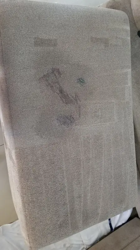 Seat cushion with dark stains across the fabric