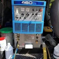Truck-mounted steam extraction unit inside the van, with jugs of cleaning solution